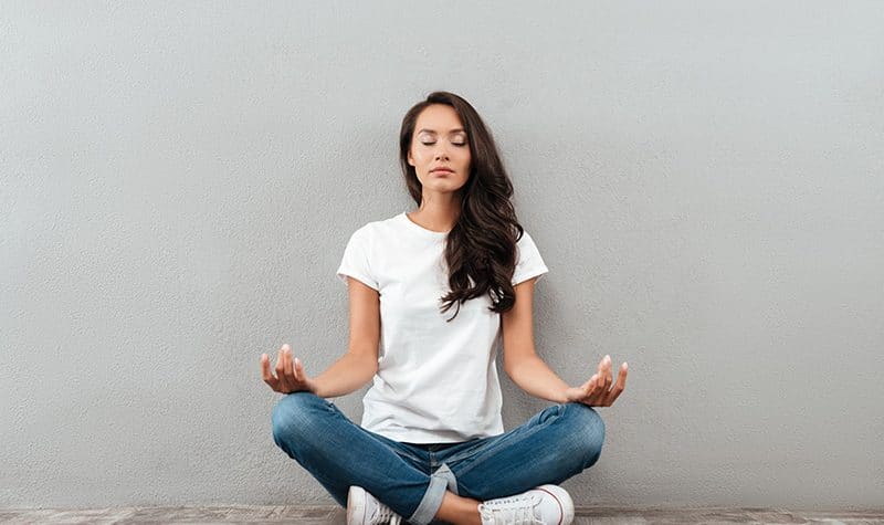 A woman practices meditation in recovery.