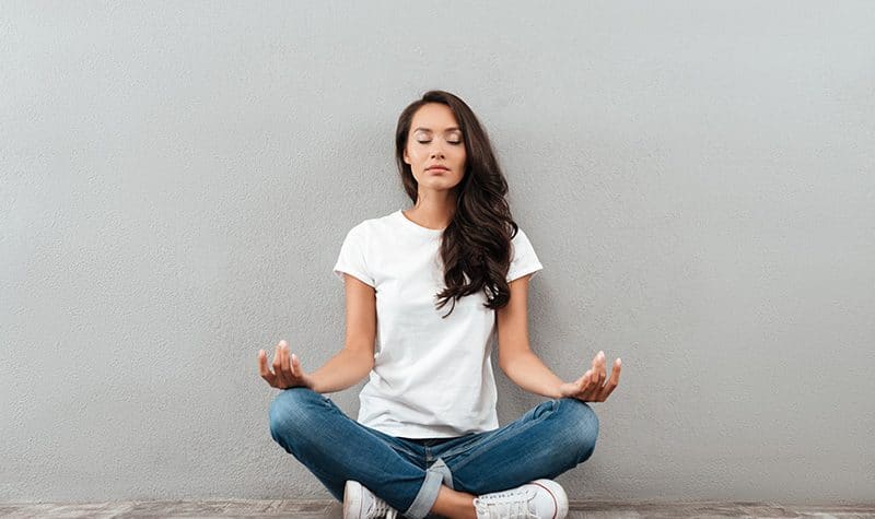 A woman practices meditation, one of the actions that can help rewire your brain from addiction.