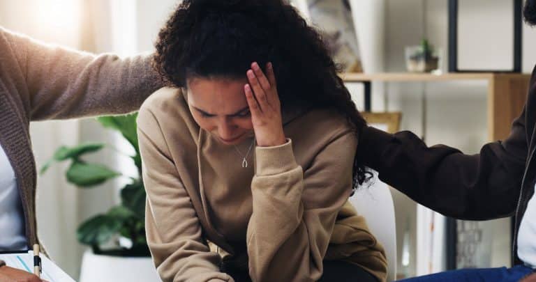 Distressed woman wondering what is a common physical reaction to trauma.